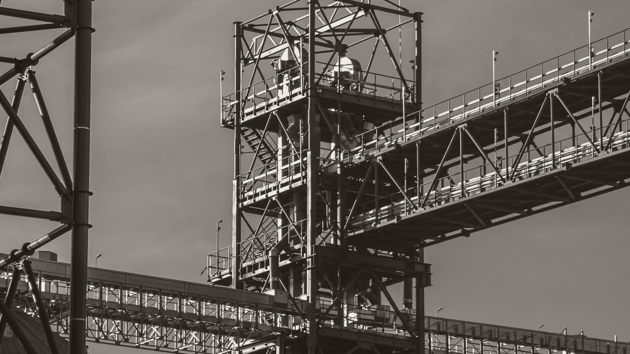 Steel gantry and conveyor structure above an industrial plant
